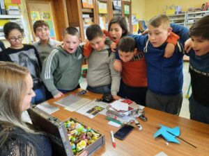 élèves, institutrice, valise avec des chocolats de Pâques