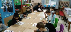 des enfants dans une classe préparent un projet sur le thème des Schtroumpfs