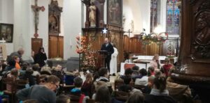Un adulte lit un texte pour une célébration de Noël dans une église
