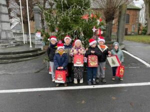 des élèves avec des déguisements de Noël sur une place