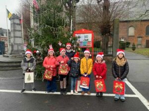 des élèves avec des déguisements de Noël sur une place
