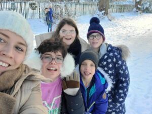 Des élèves dehors dans la neige avec leur institutrice