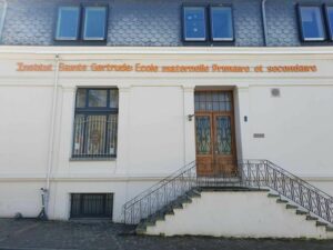 La façade de l'école Sainte-Gertrude à Brugelette : travaux terminés, avec les lettres sur le mur "Institut Sainte Gerturd Ecole maternelle Primaire et secondaire"